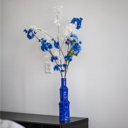 Blauwe hoge vaas op een dressoir