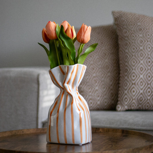 Vaas met oranje strepen en oranje tulpen 